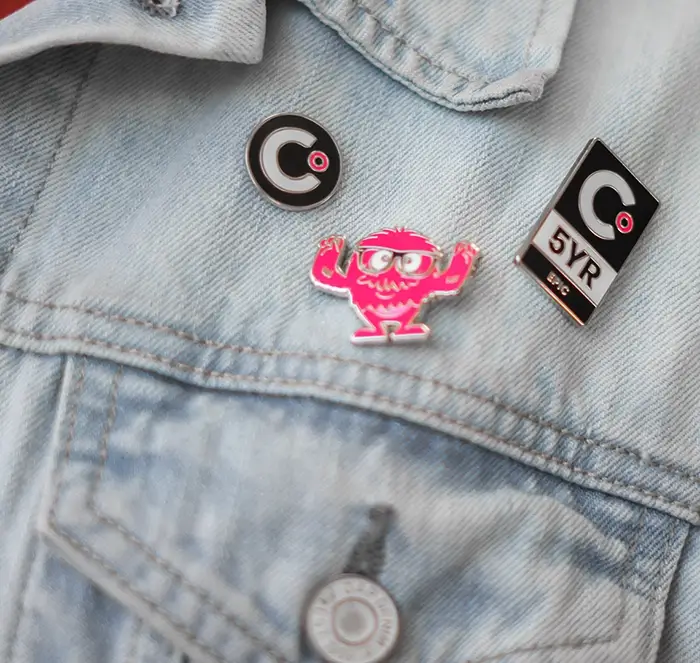 Pins of Clear Digital on a blue jean jacket, close up macro shot.